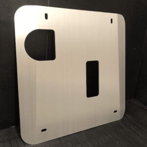 Metal skid plate with cutouts, designed for mounting or protection. Textured background.