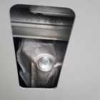 Close-up of a metal component with a visible bolt and engraved numbers.