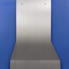 Metal transmission cover plate with mounting holes, placed against a blue background.