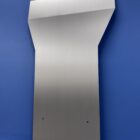 Metal transmission cover plate mounted against a blue background, featuring holes for installation.