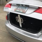 Open trunk of a silver Honda Accord, showing a license plate and a white object inside.