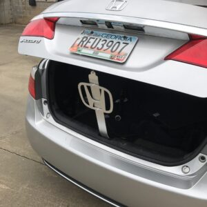 Open trunk of a silver Honda Accord, showing a license plate and a white object inside.