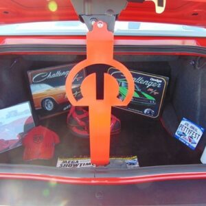 Trunk filled with car memorabilia, including posters, a red hat, and a fire extinguisher. An orange prop is visible.