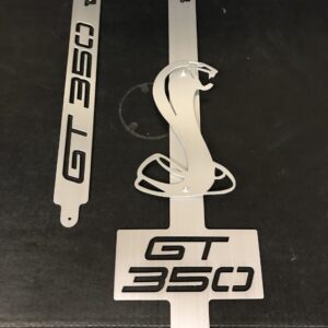 Three metal car emblems labeled "GT 350" and a cobra logo on a dark background.