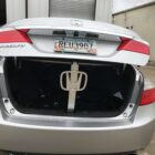 Open trunk of a silver Honda Accord, showing a trunk prop and items inside. Georgia license plate visible.