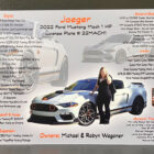 A woman stands beside a customized 2022 Ford Mustang Mach 1, showcasing modifications and specifications.